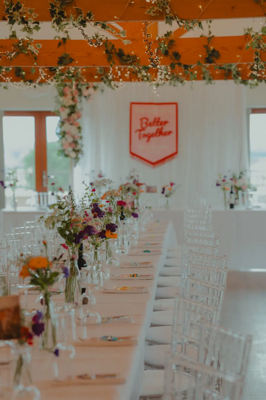 Hall tables beneath bright fringe and a red Better Together sign