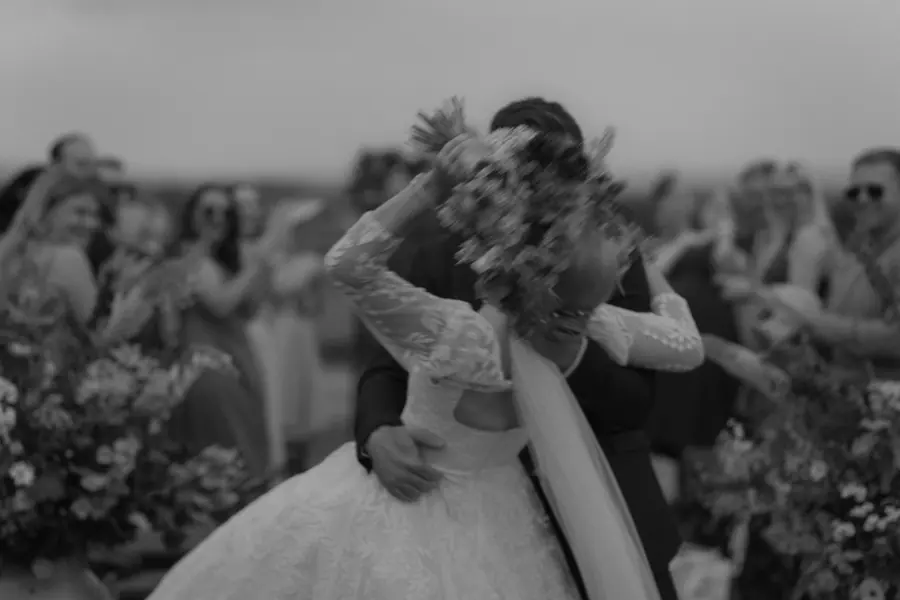 The couple standing together outdoors in a black and white close view