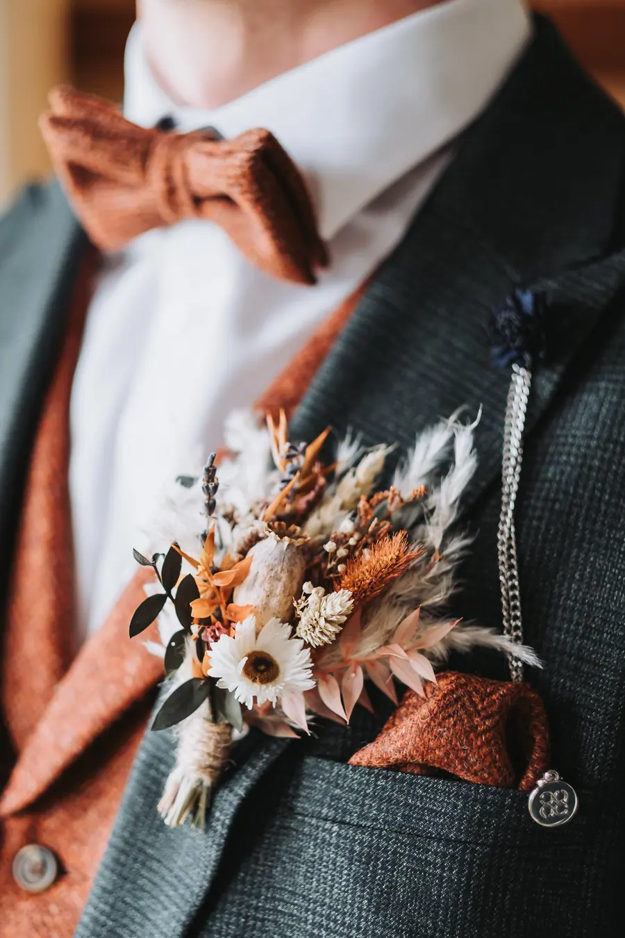 Joe's rust bow tie and dried-flower buttonhole against his green suit