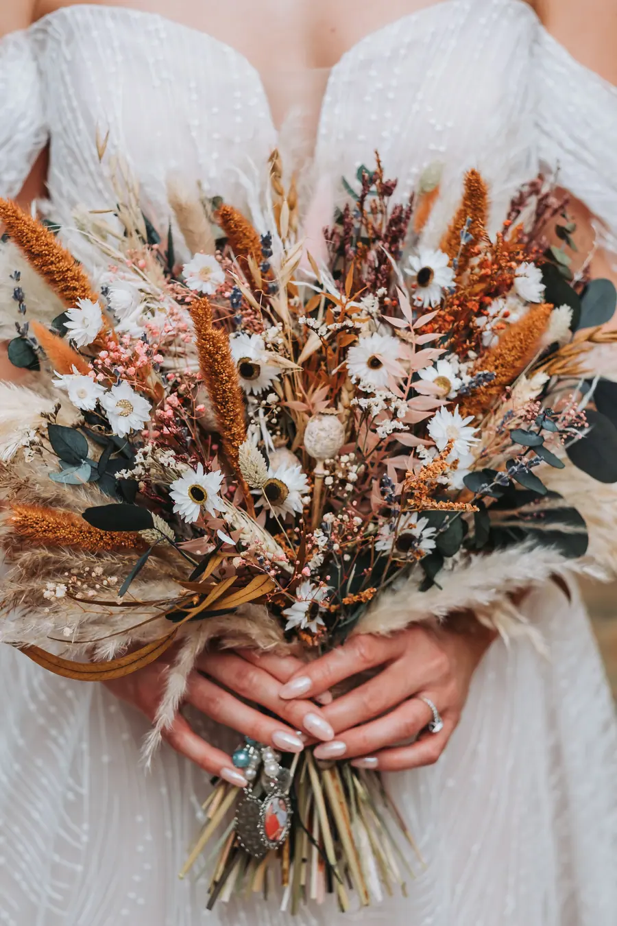 Evie-Mae holding a bouquet of dried grasses and white flowers
