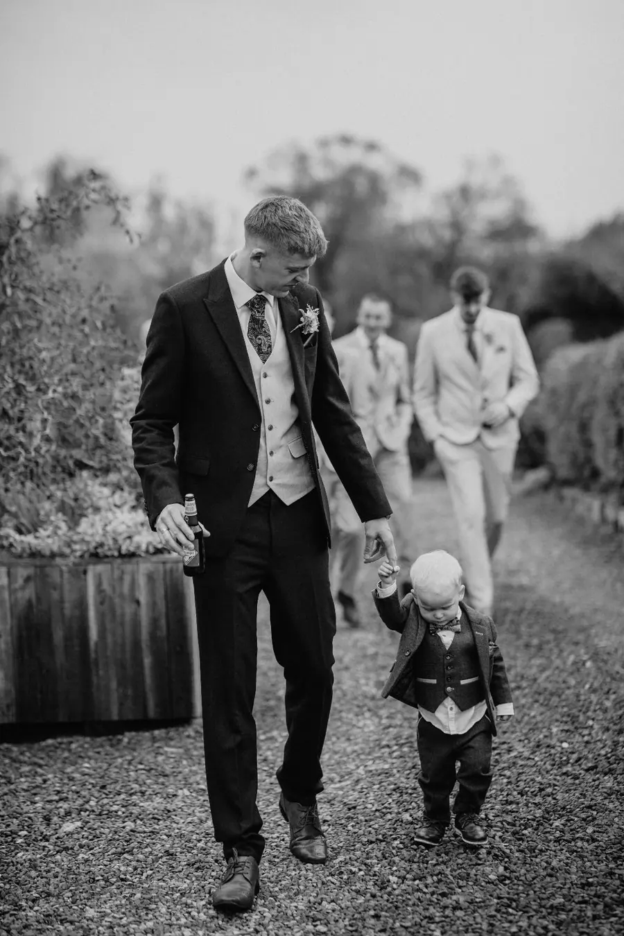 Jack walking hand in hand with a young boy across the gravel
