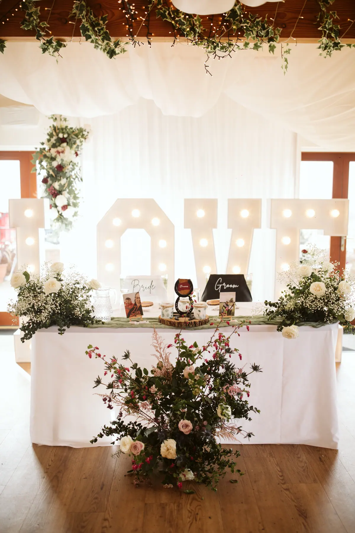 White top table with flowers and illuminated letters inside the Hall