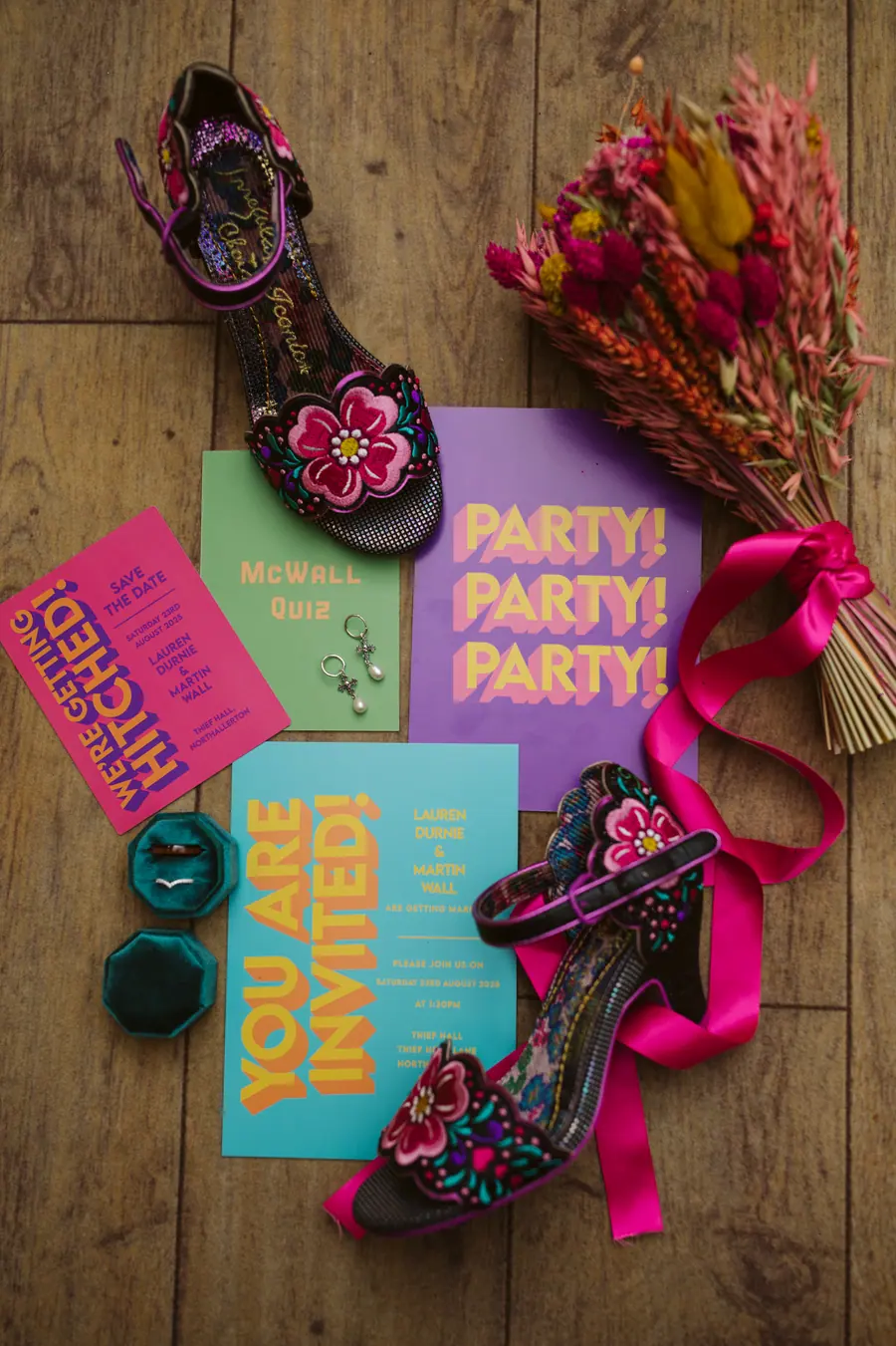 Turquoise ring boxes, bright stationery, shoes and ribboned flowers on wood