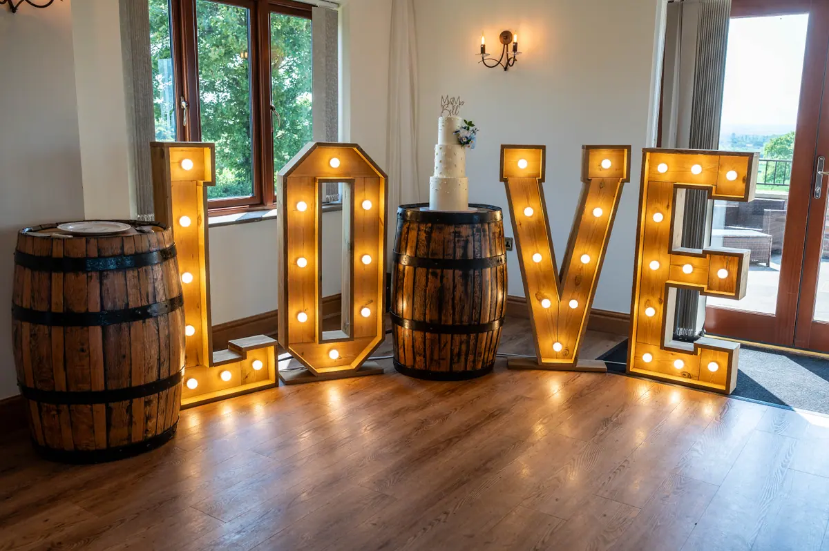 Illuminated LOVE letters standing between wooden barrels inside the Hall