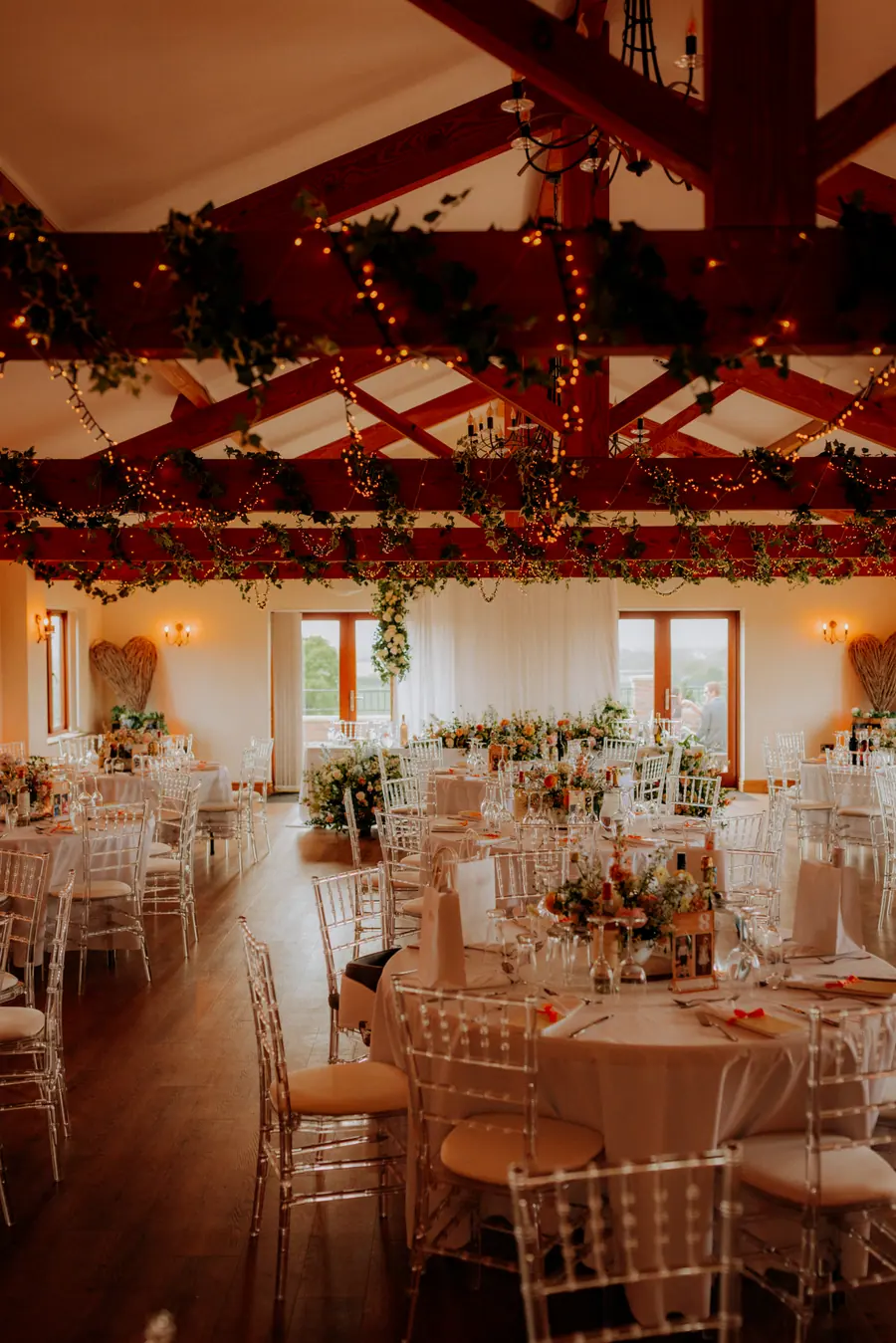 Hall dining room filled with clear chairs, candles and flower arrangements
