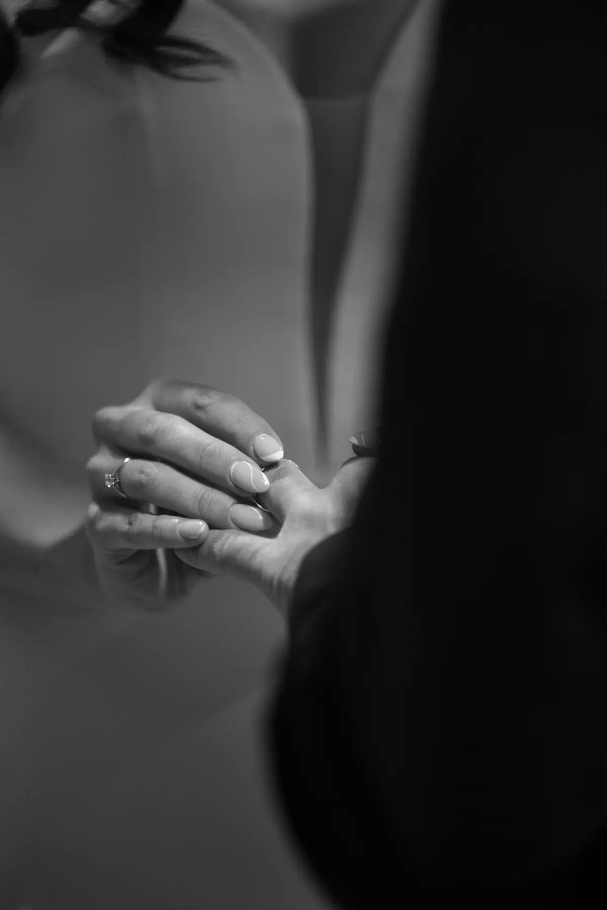 Close black and white view of the couple's hands and rings