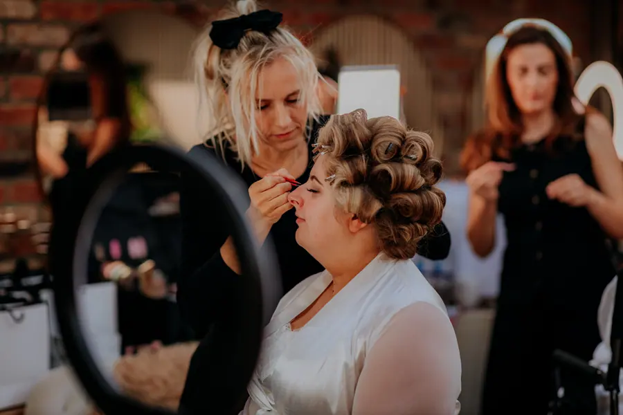 Olivia having her hair prepared in rollers while seated indoors