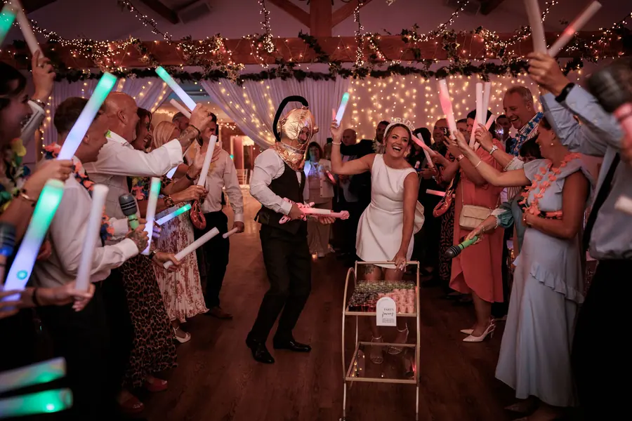 Guests holding coloured light sticks around Sophie and Ben on the dance floor