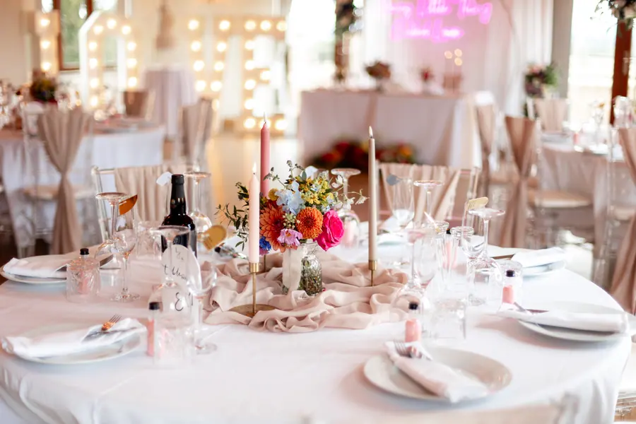 White table settings with pale flowers, glassware and beige napkins