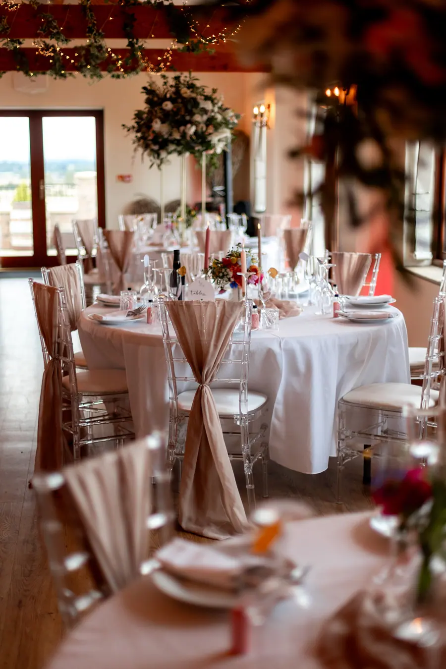 Close table view with clear glasses, folded napkins and pale flowers