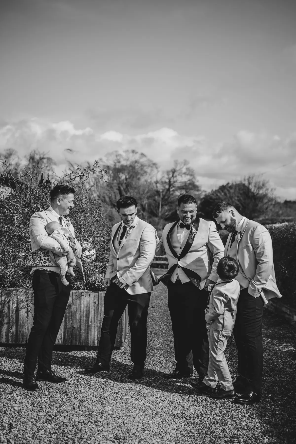 Dan standing outdoors with five men in a black and white view