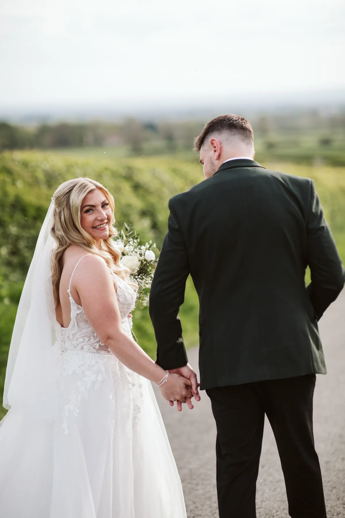 Lauren and Iain holding hands outside on their wedding day