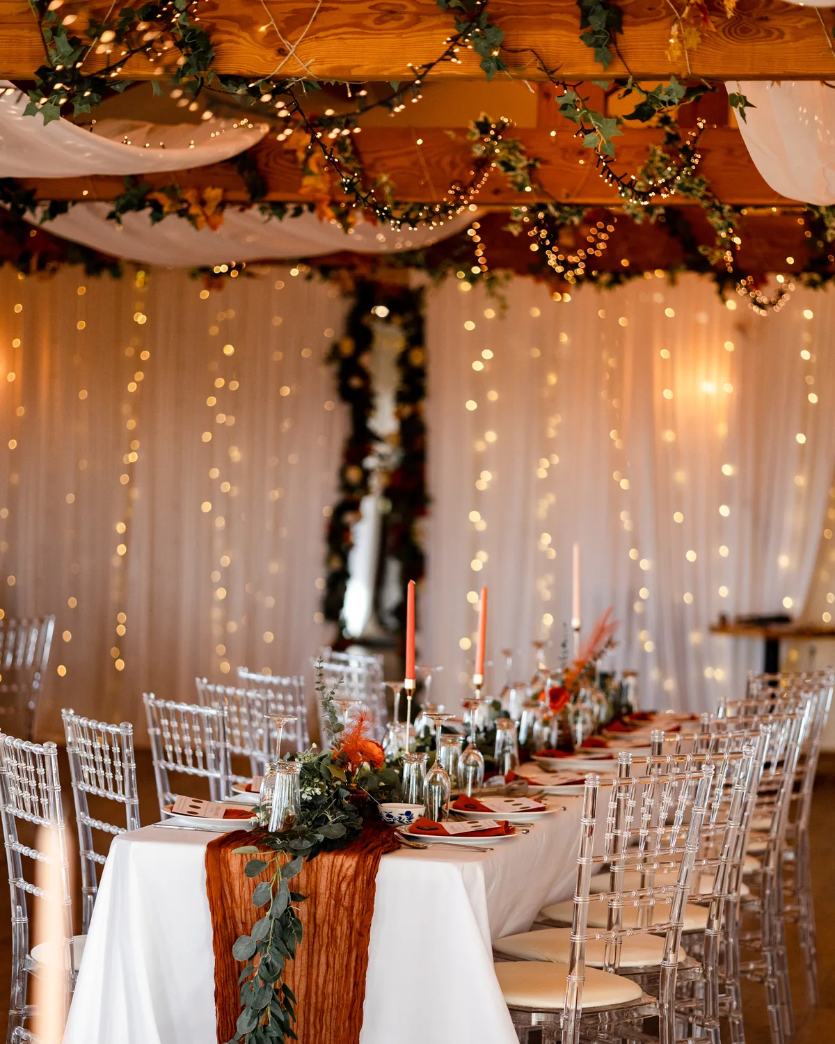 A wedding breakfast table with autumn decorations and fairy lights at Thief Hall