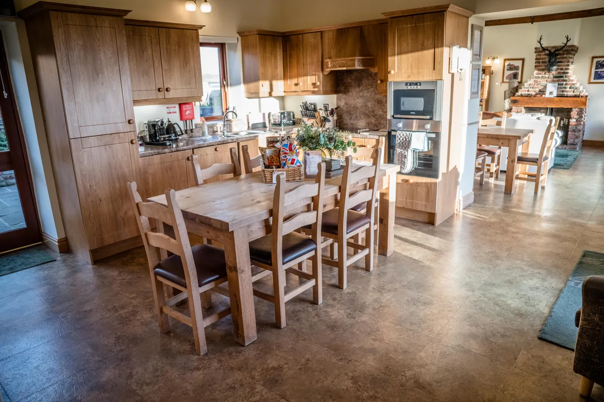 The kitchen and dining table looking through to the fireplace in Thief Hole Barn