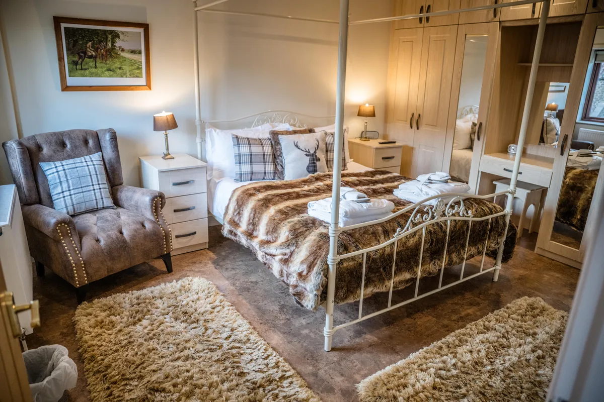 The white metal four-poster bed in Turpin Cottage