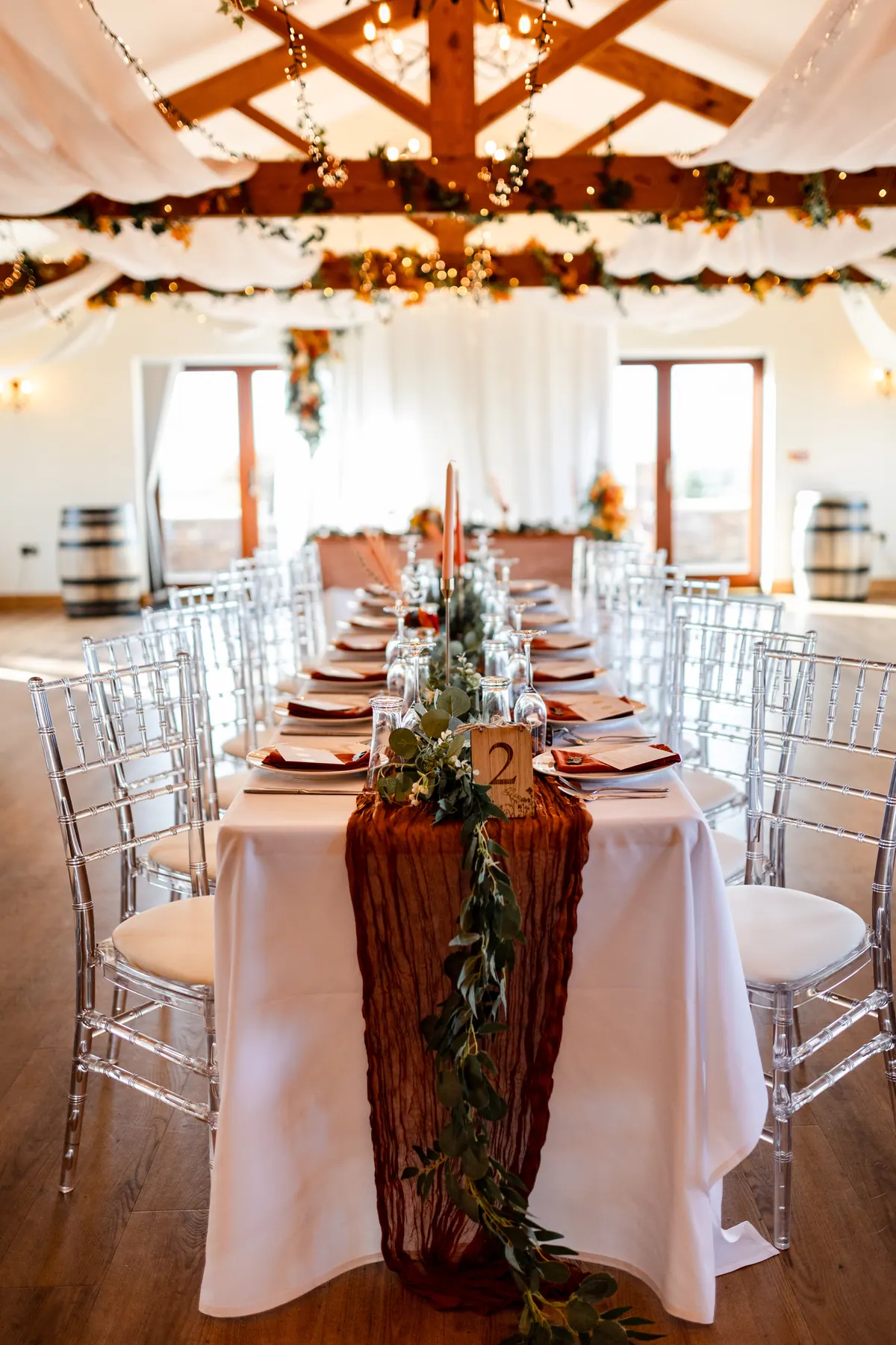 Long wedding breakfast tables dressed in rust and cream inside the Hall